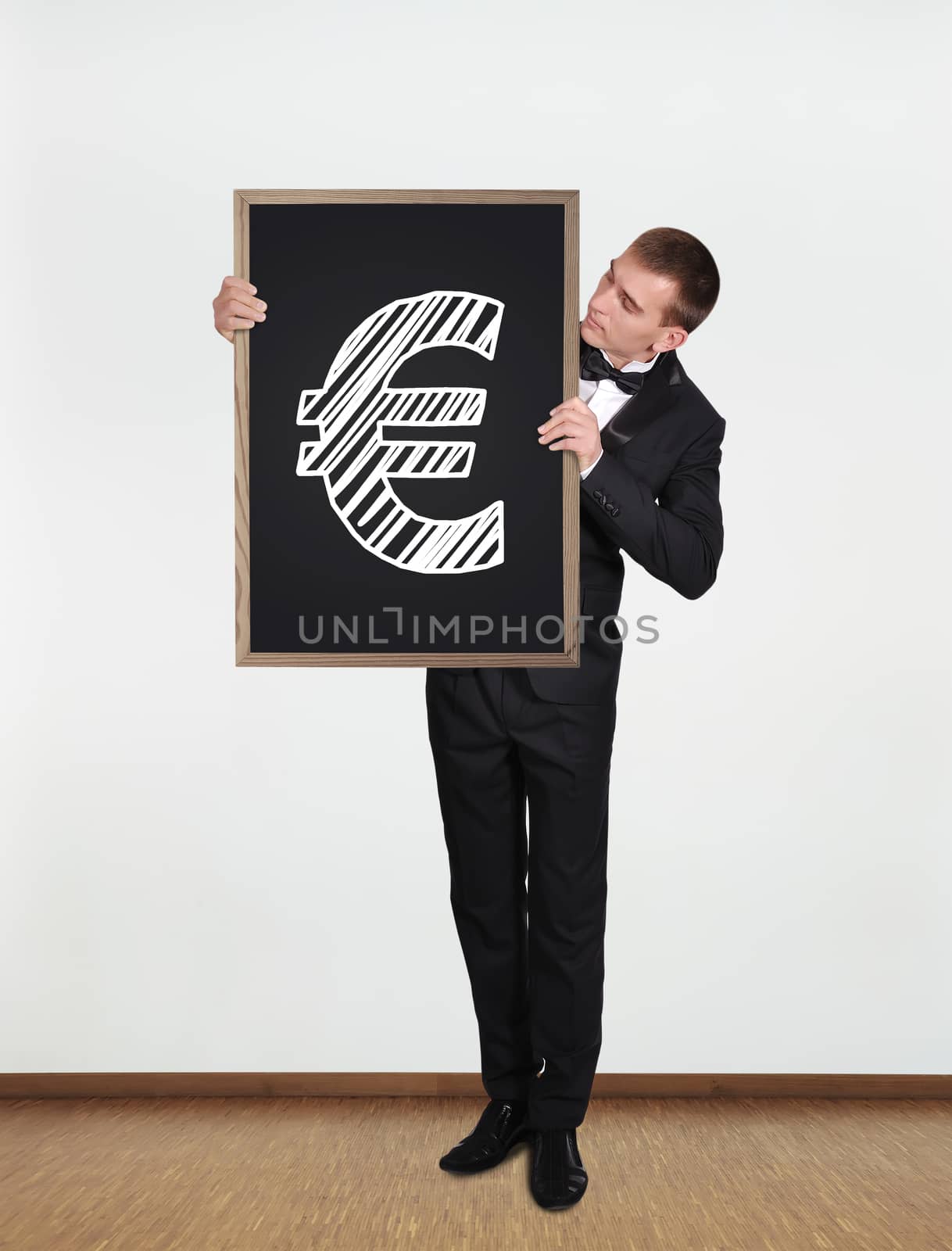 businessman standing in office and  holding blackboard with euro symbol