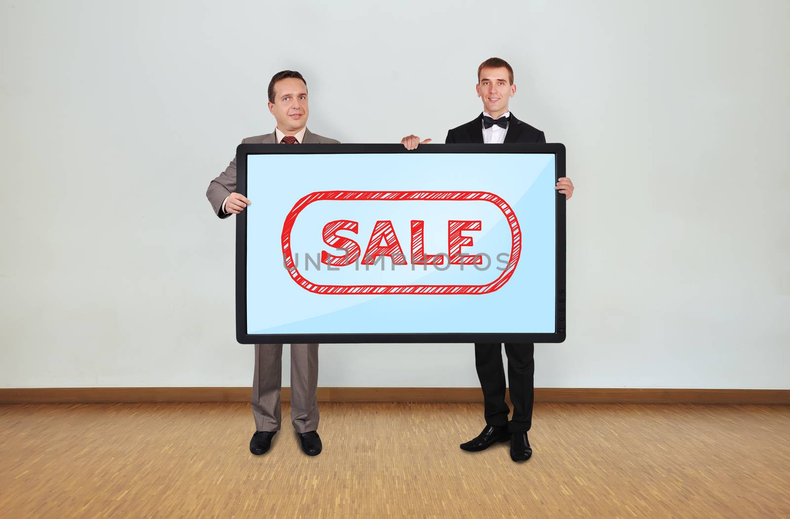 two businessman in room holding plasma panel with sale