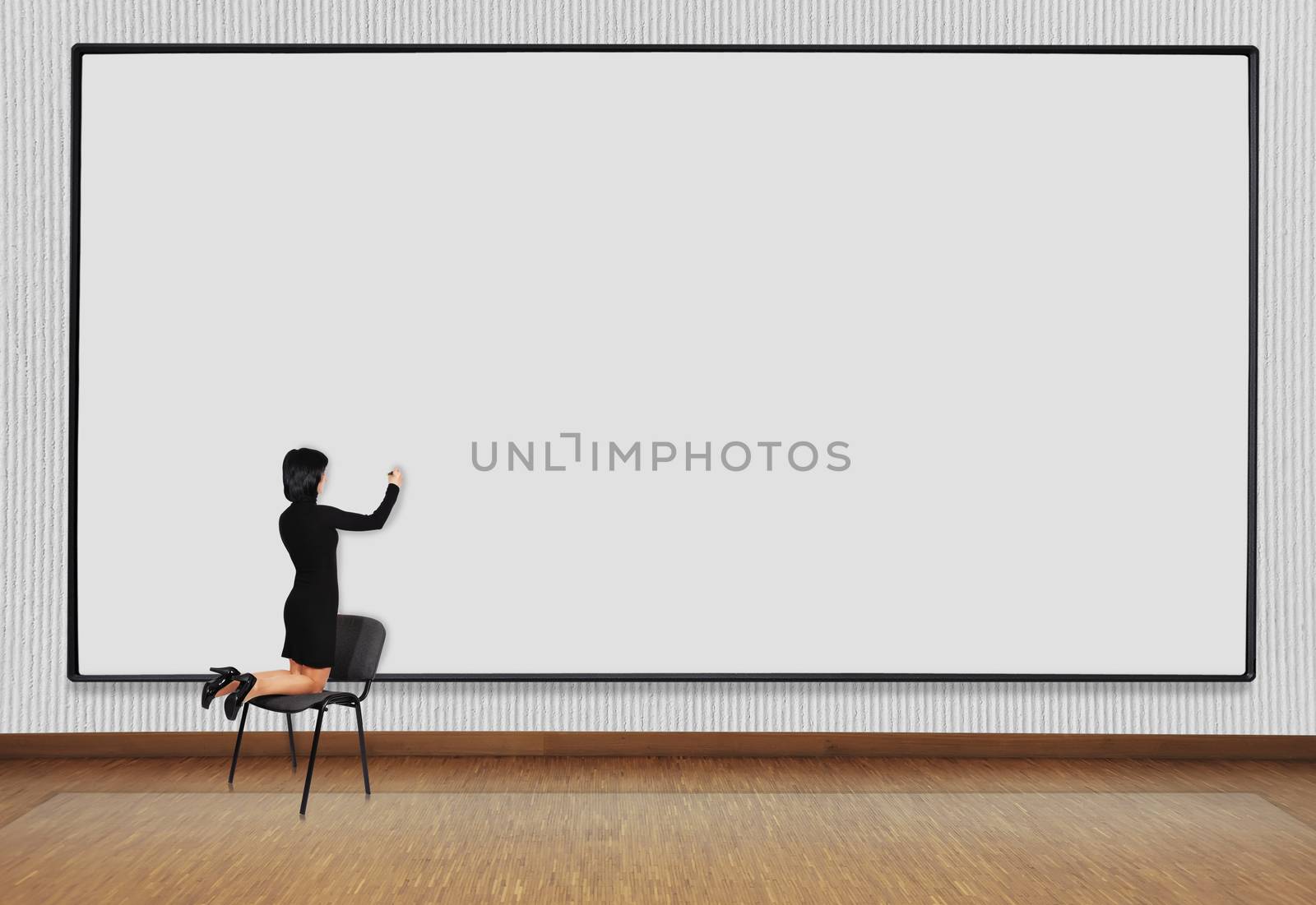 woman standing on a chair and drawing on blackboard