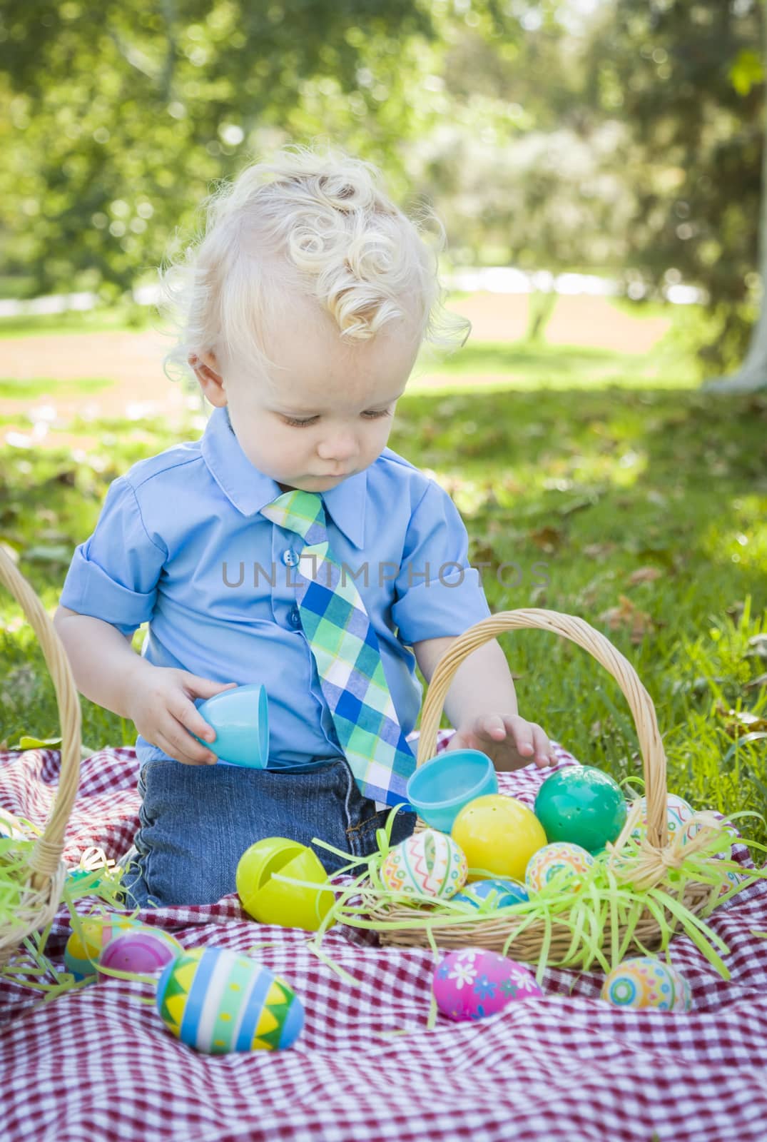 Cute Little Boy Enjoying His Easter Eggs on Picnic Blanket Outside in the Park.