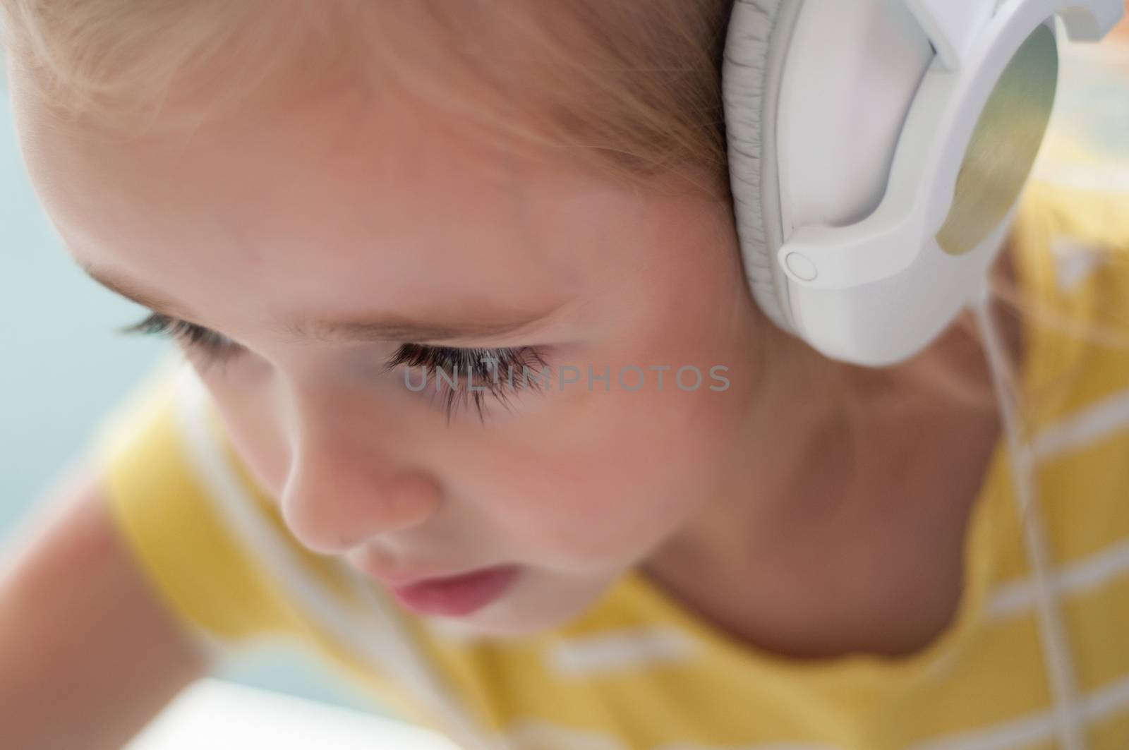 Little blond girl in headphones by anytka