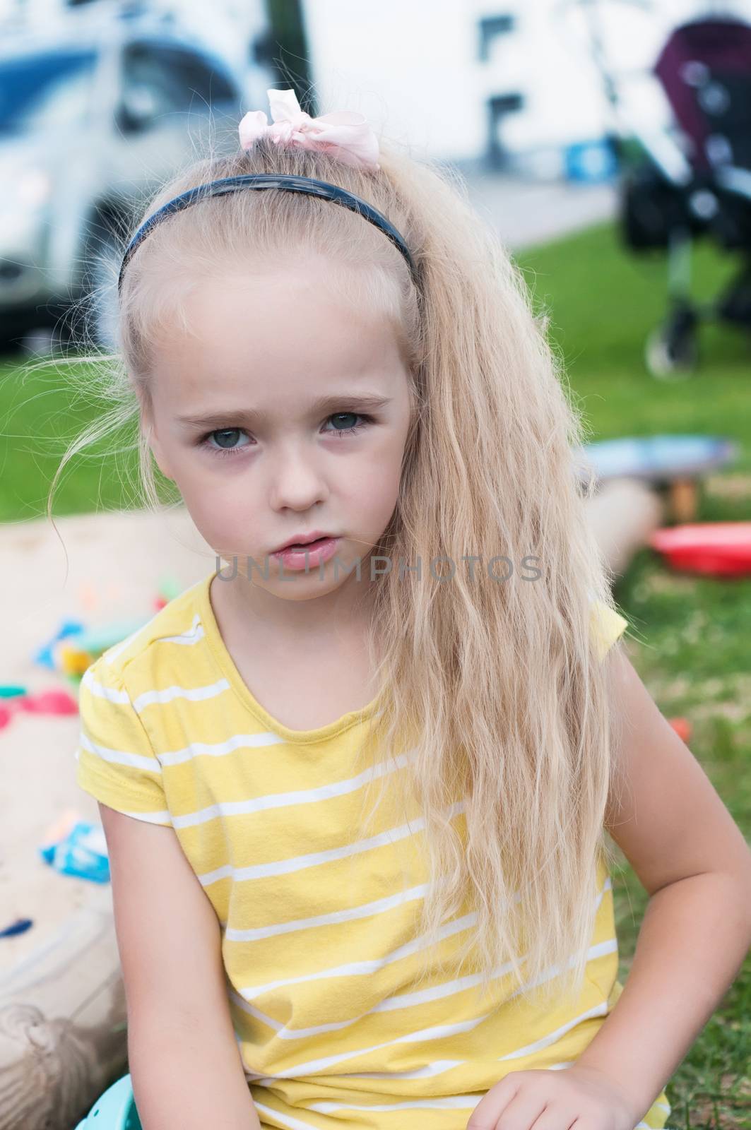 Portrait of beautiful little girl with long hair watching on you
