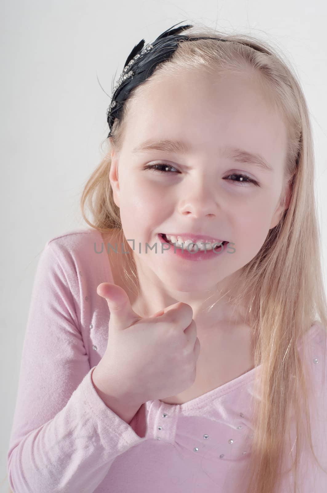 Little girl in pink with thumb up
