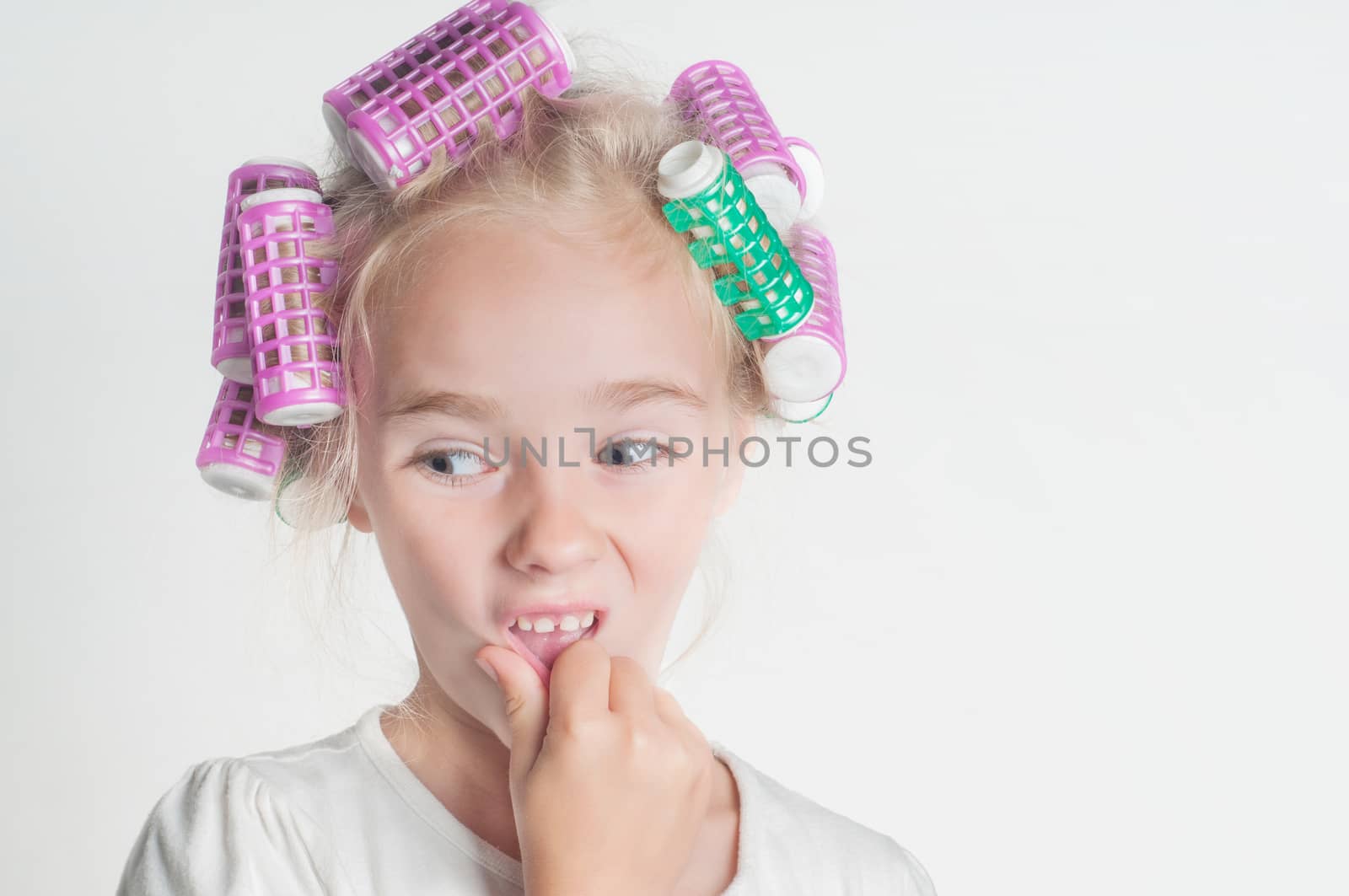 Portrait of little girl in hair-curler, studio