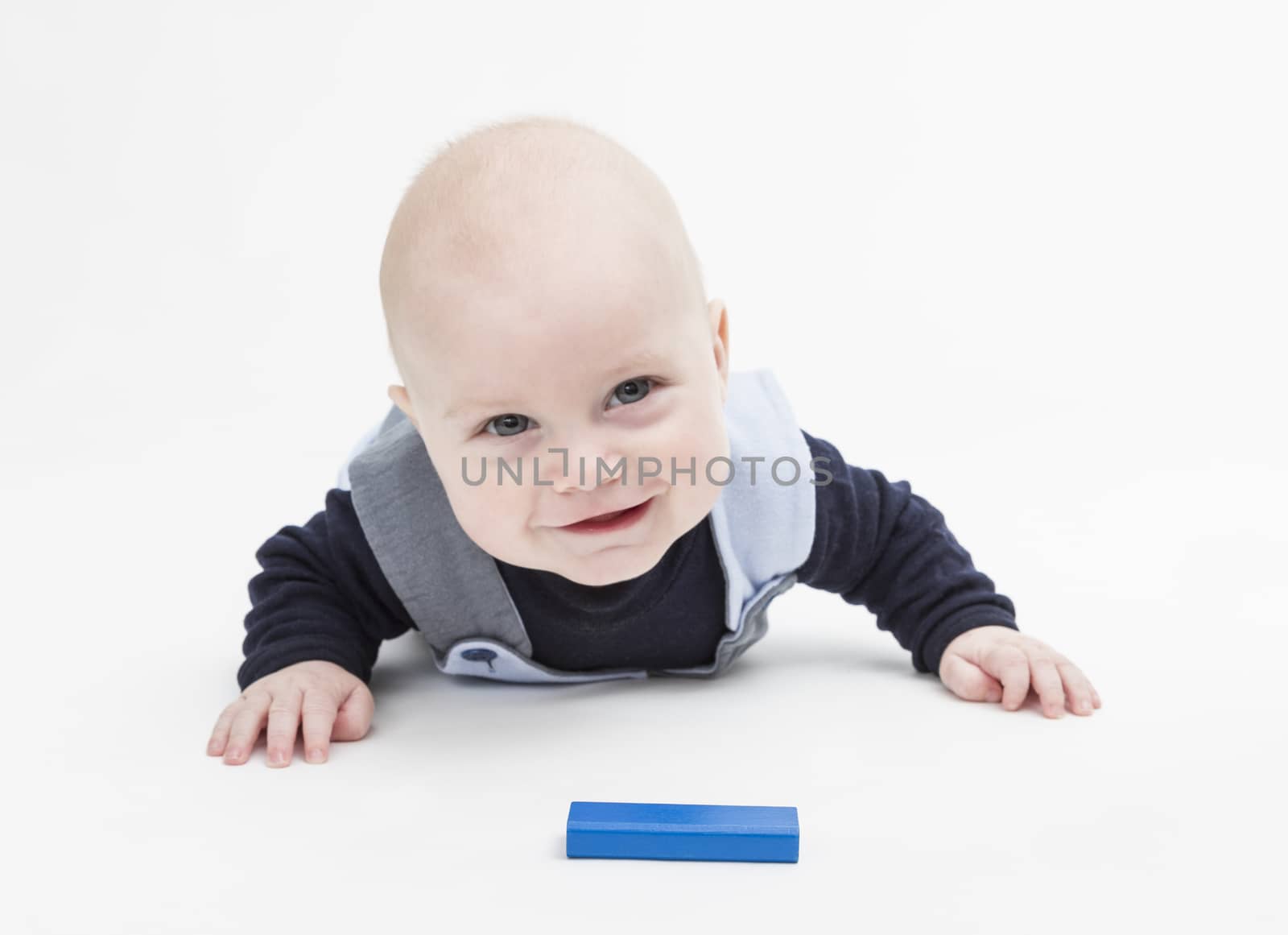 interested baby with toy block on floor isolated on white