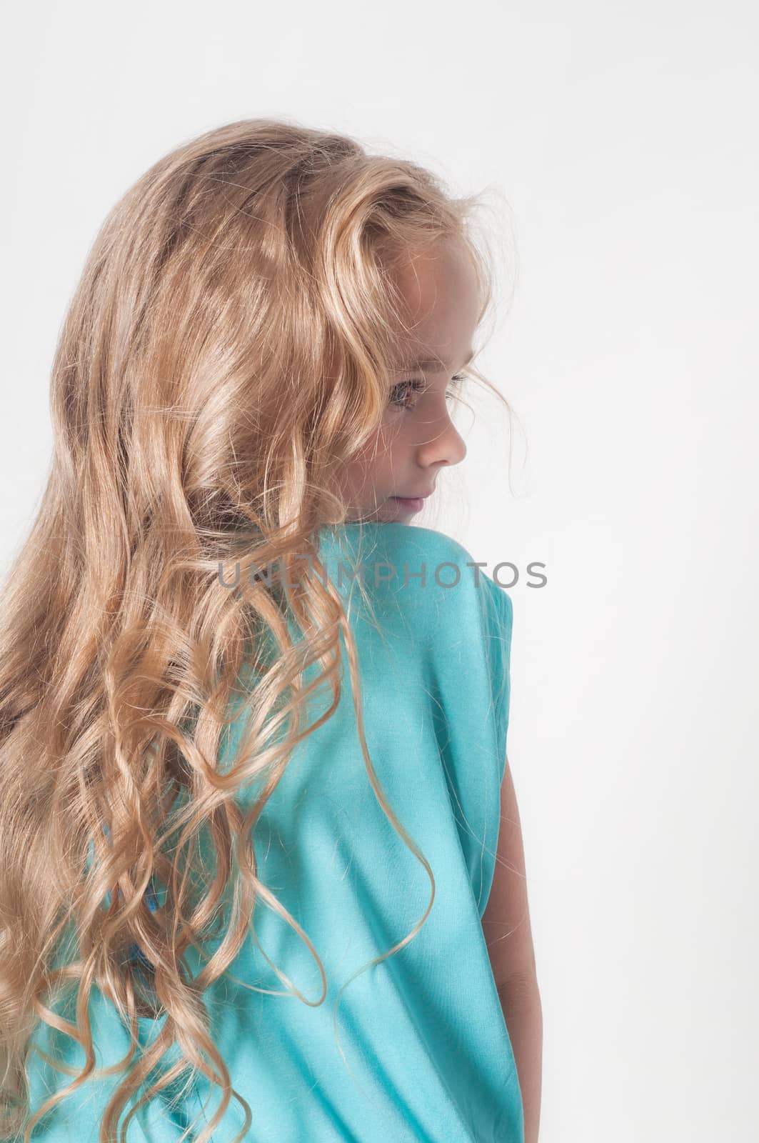 Photo from the back of little girl on light background
