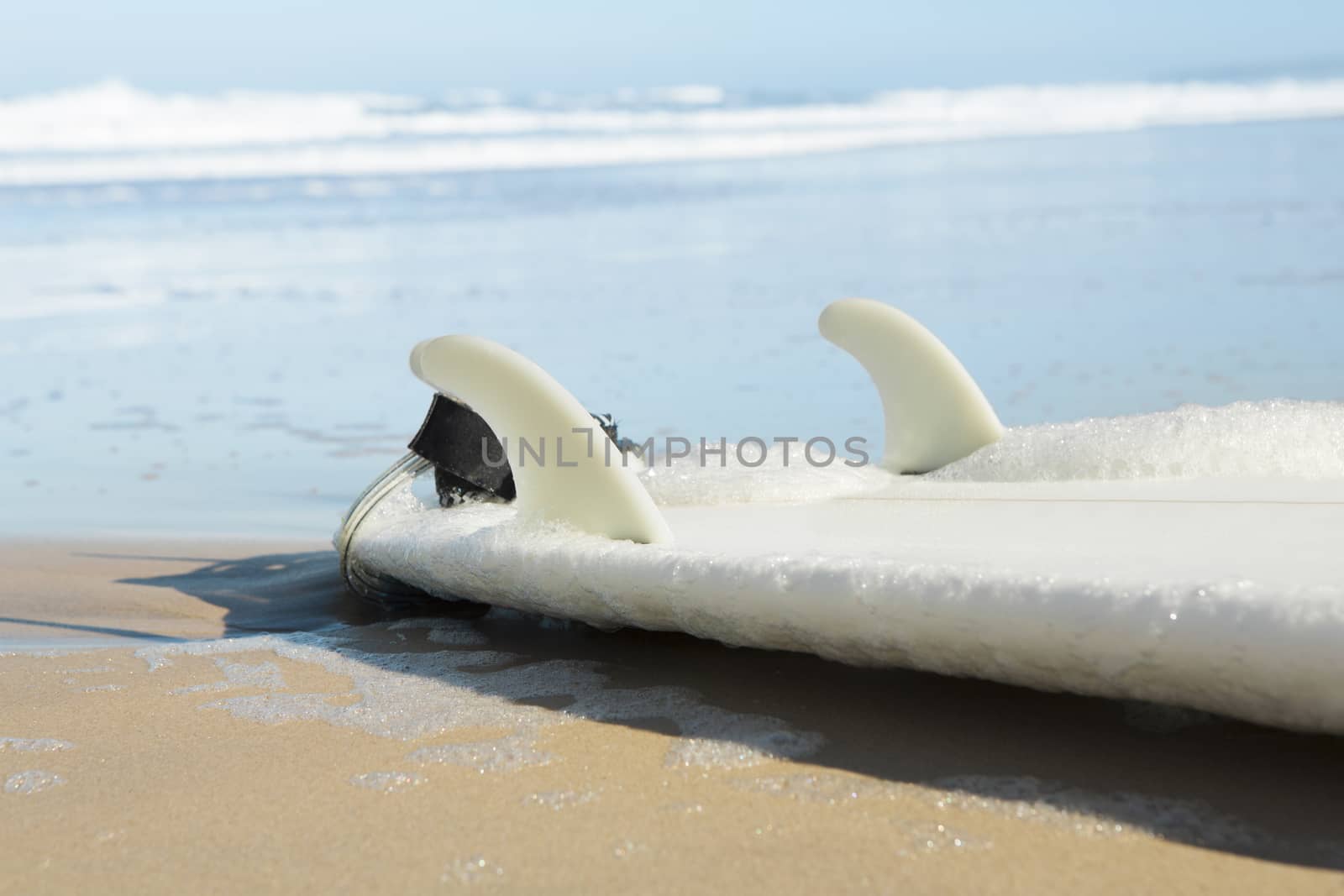 Red surfboard on the sand on a very beautiful sunny day