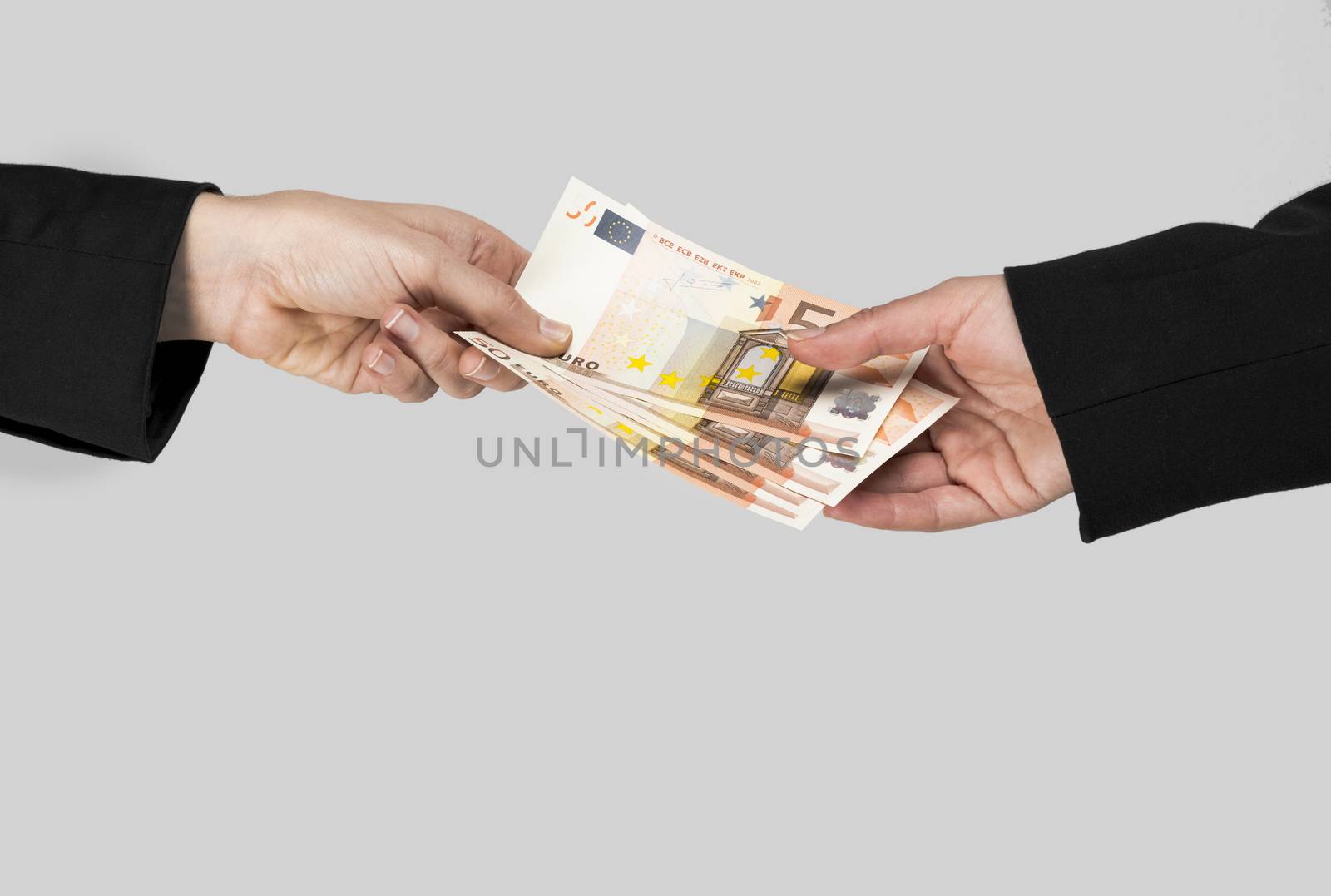 Concept image of hands making and receiving a payment, isolated over a gray background