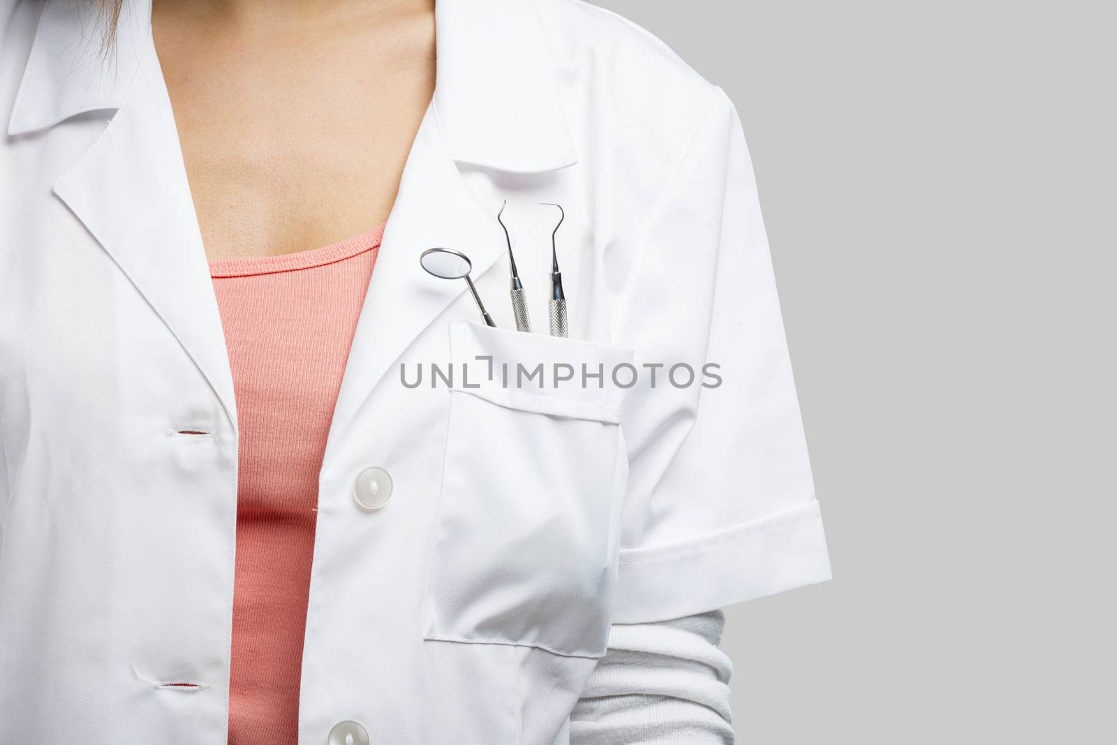 Female dentist with tools, isolated over a white background