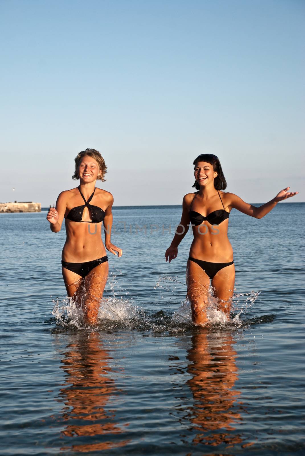 Happy young girls running on water