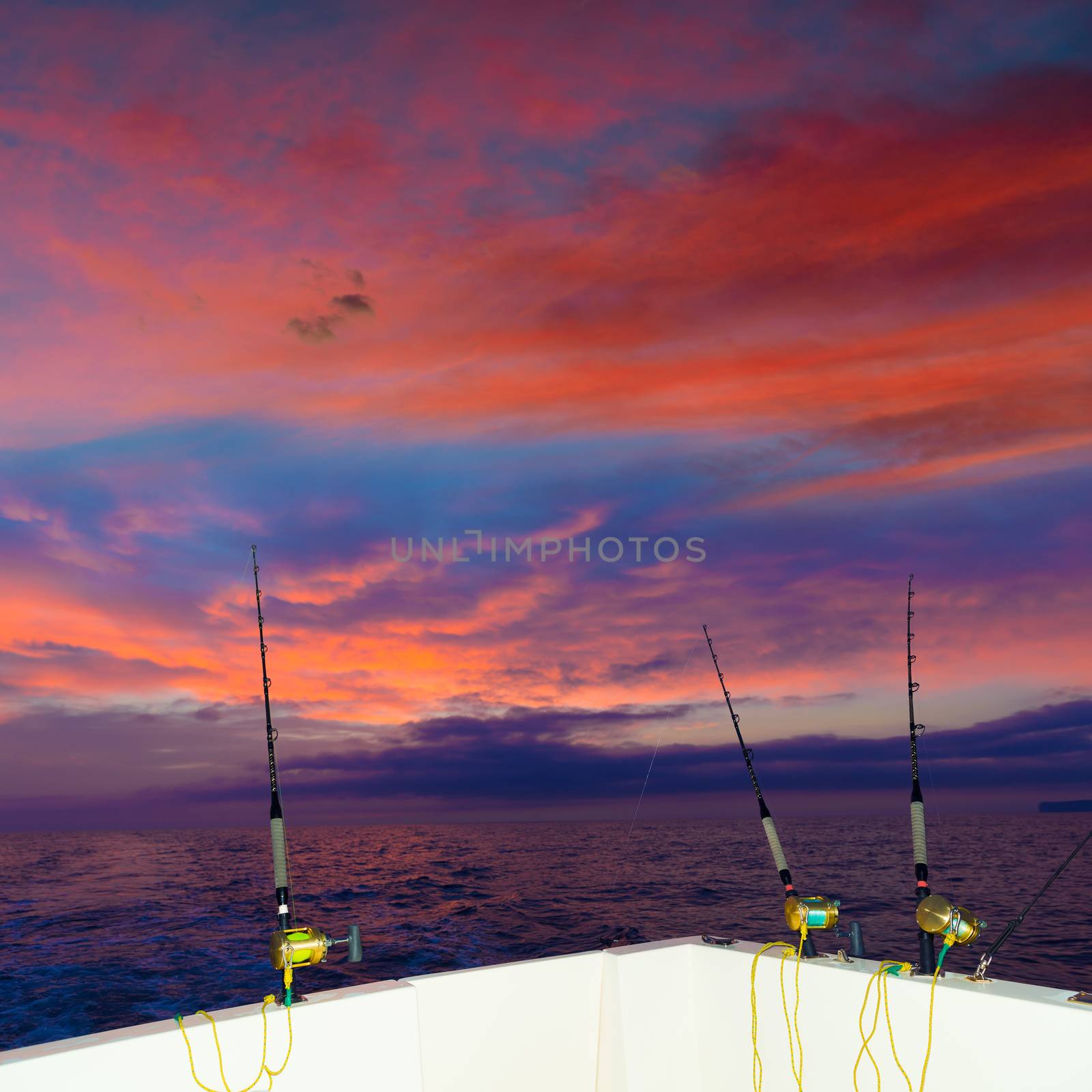 boat fishing trolling at sunset big game with rods and reels in saltwater