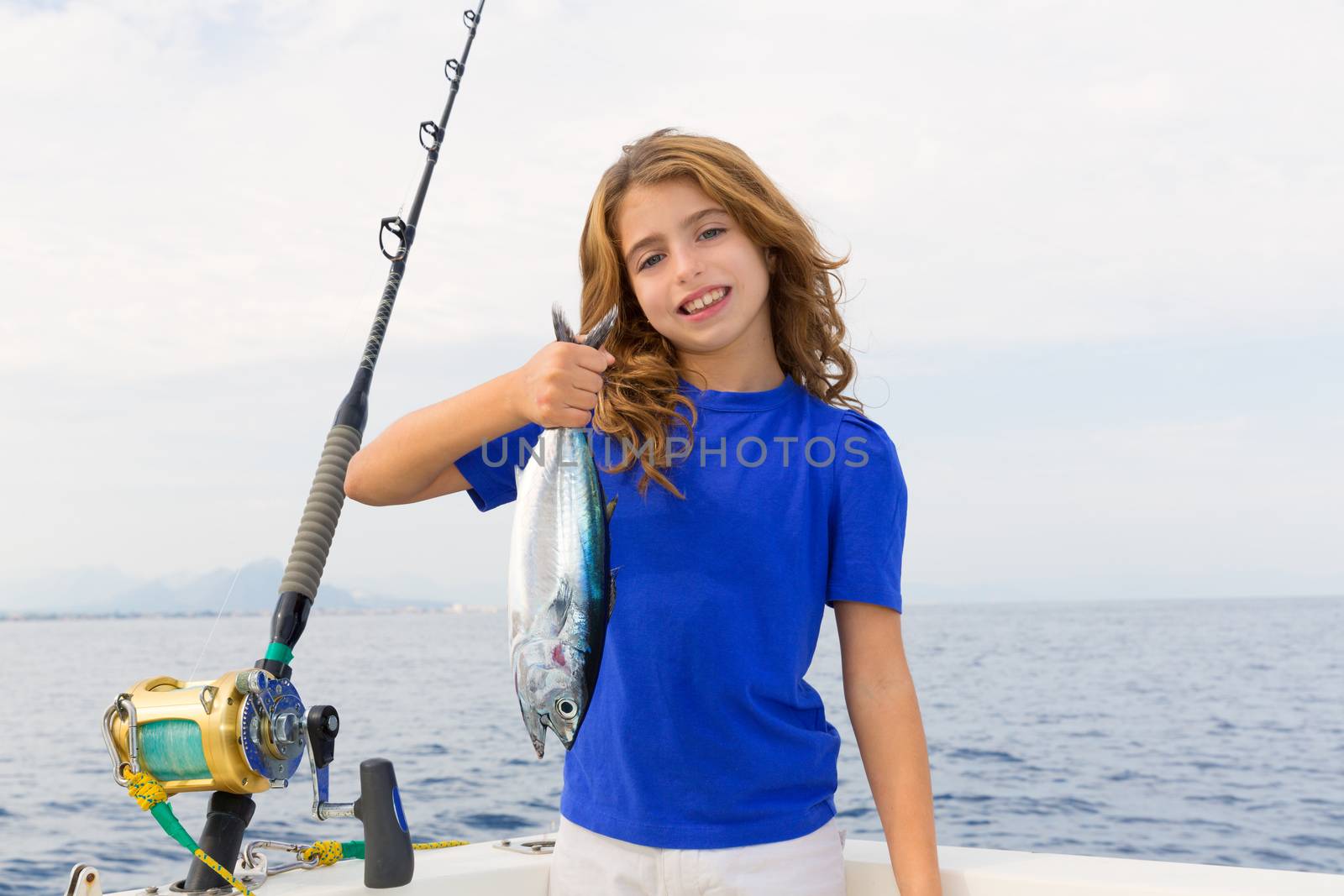 Blond girl fishing bluefin tuna trolling in Mediterranean by lunamarina
