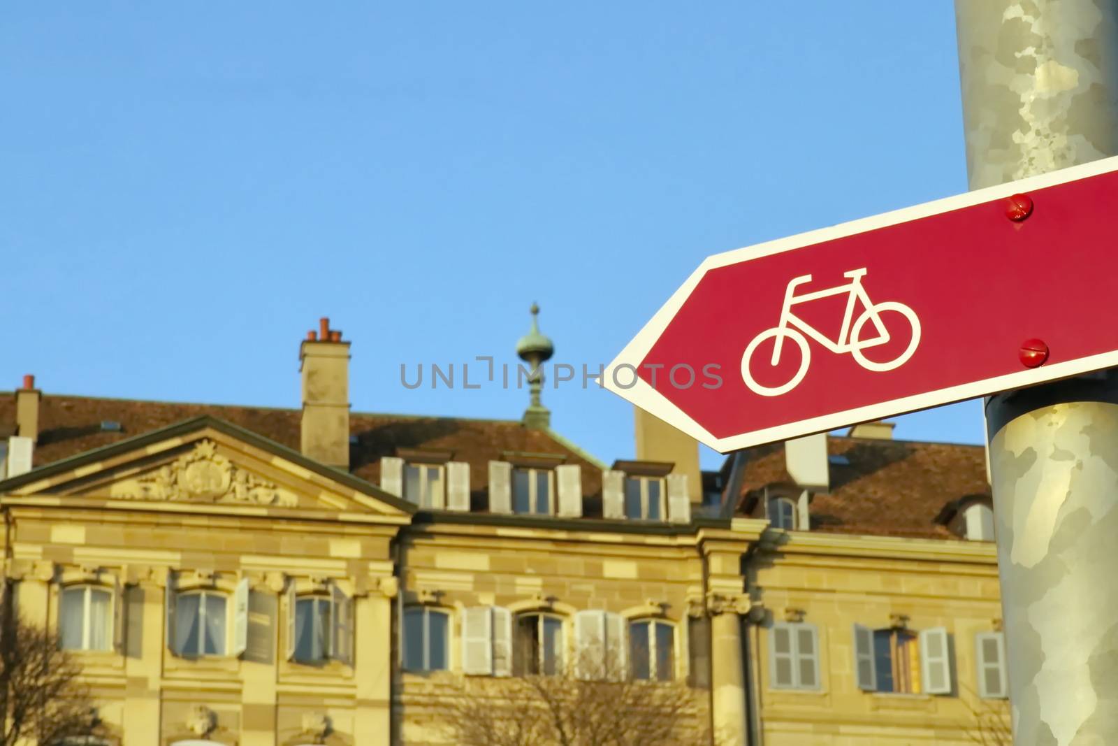 Close up on a bicycle signpost in front of old buildings, Geneva, Switzerland