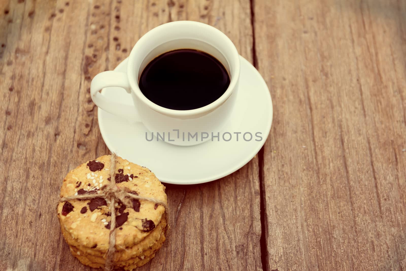 cup of coffee with cookies on wooden table 