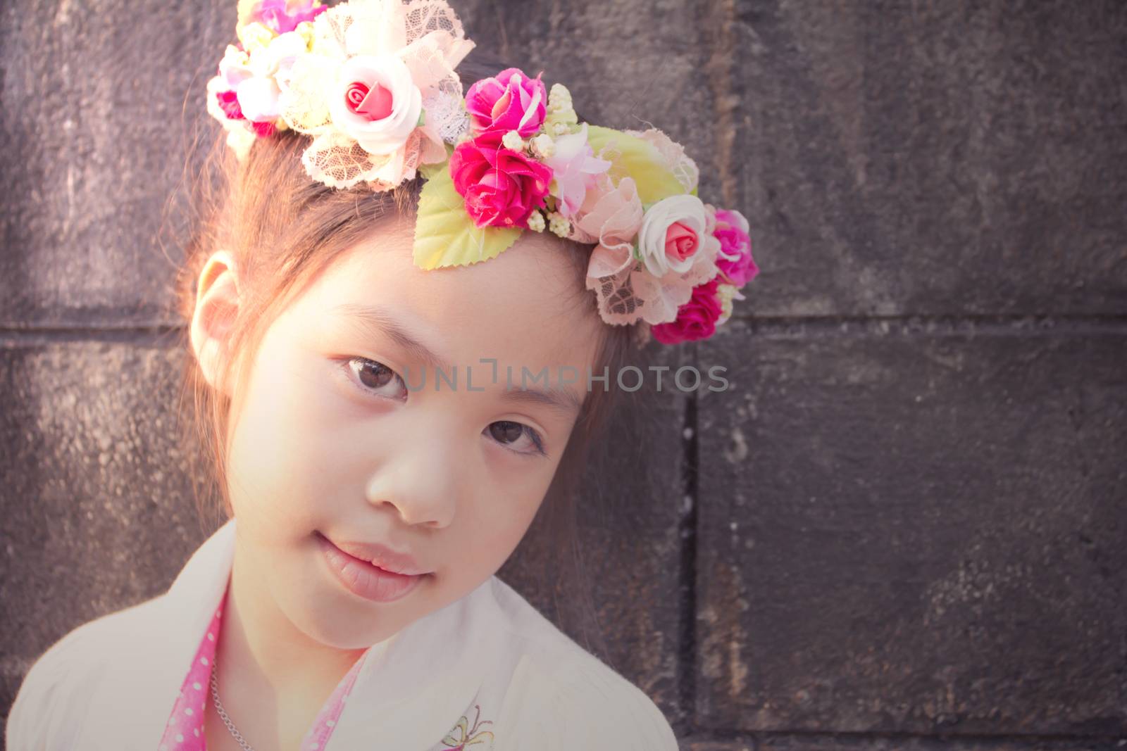 Lovely little girl with flowers on the head, vintage texture 