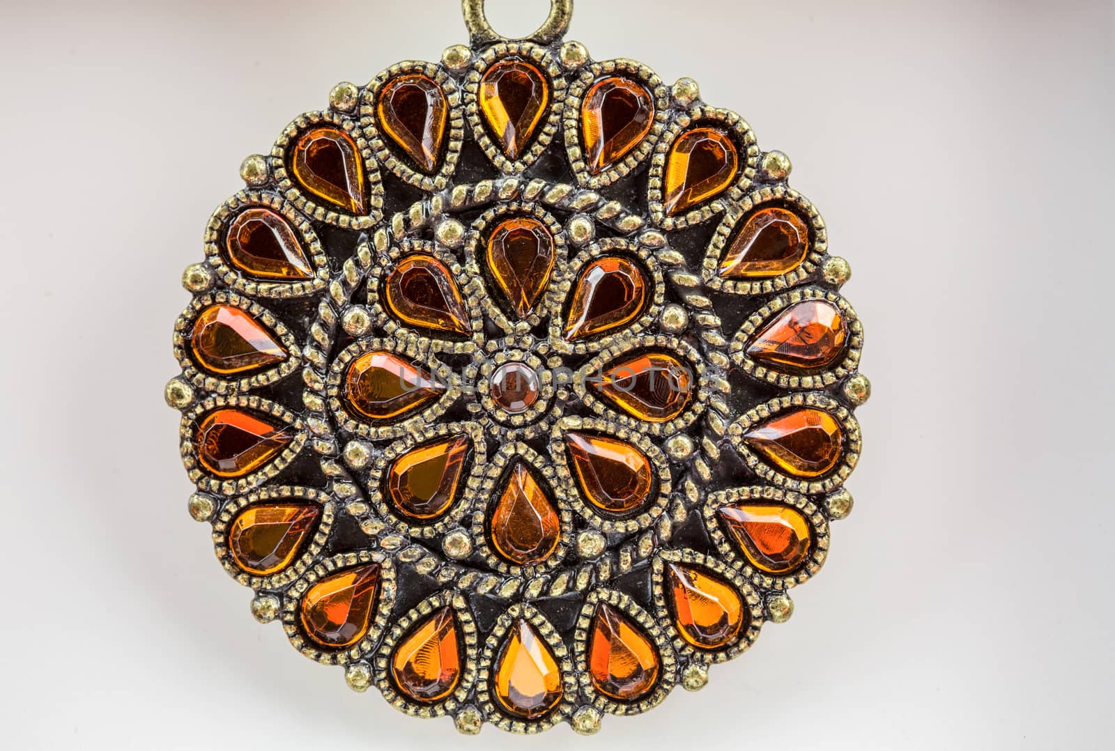 Sparkling orange gems adorn this bronzed circular neck piece. 