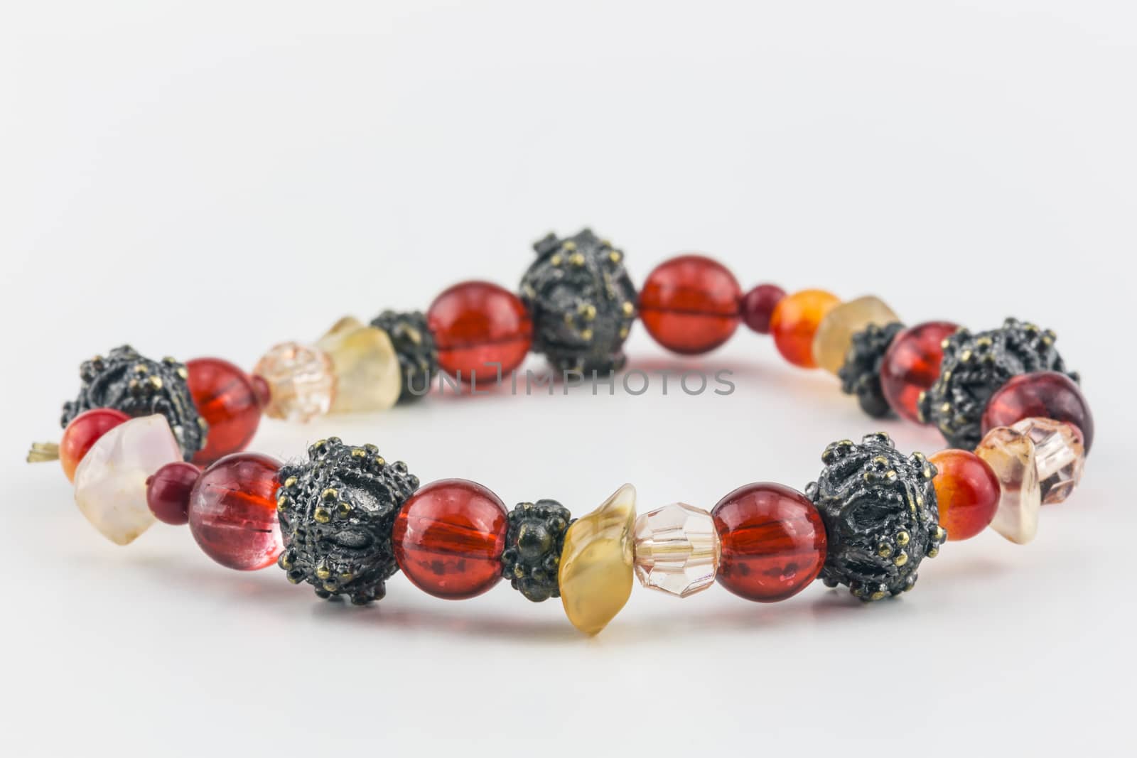 Bracelet of red, orange, metallic, and clear beads.