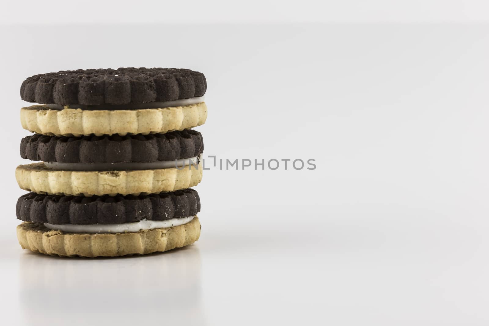 Stack of black and white sandwich cookies on white.