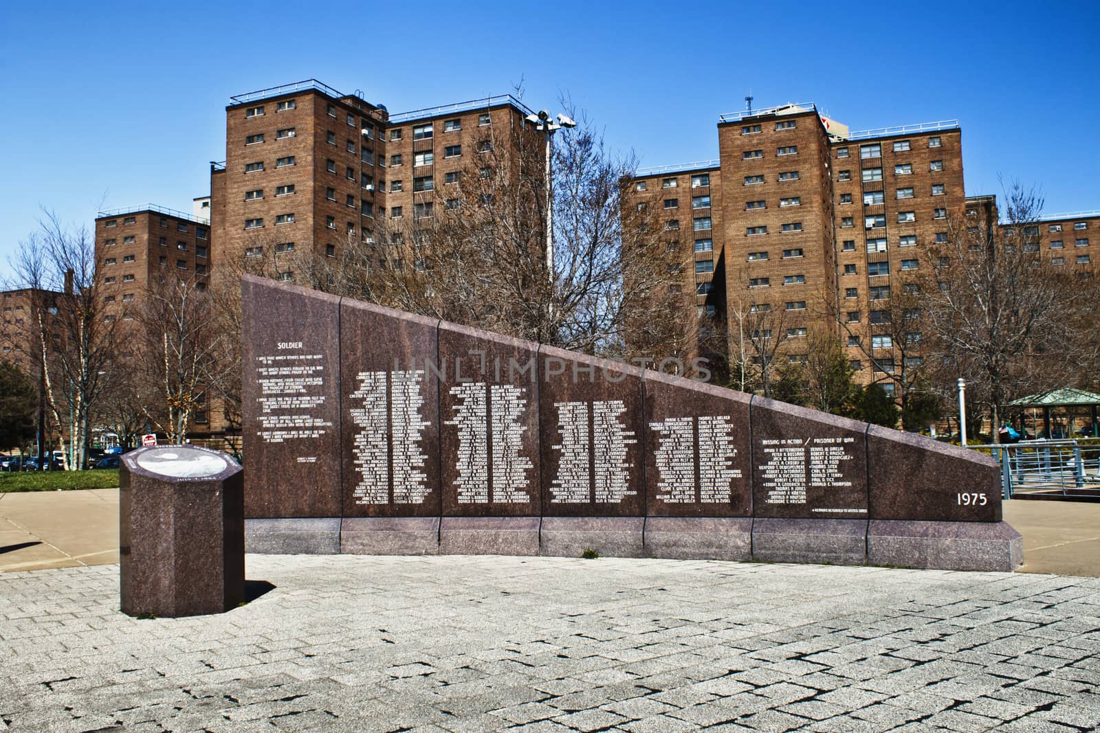 Marble wall with fallen soldier names stands tall in front of the city projects. 