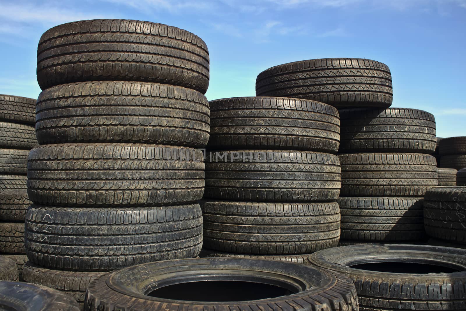Stacks of car tires with blue sky