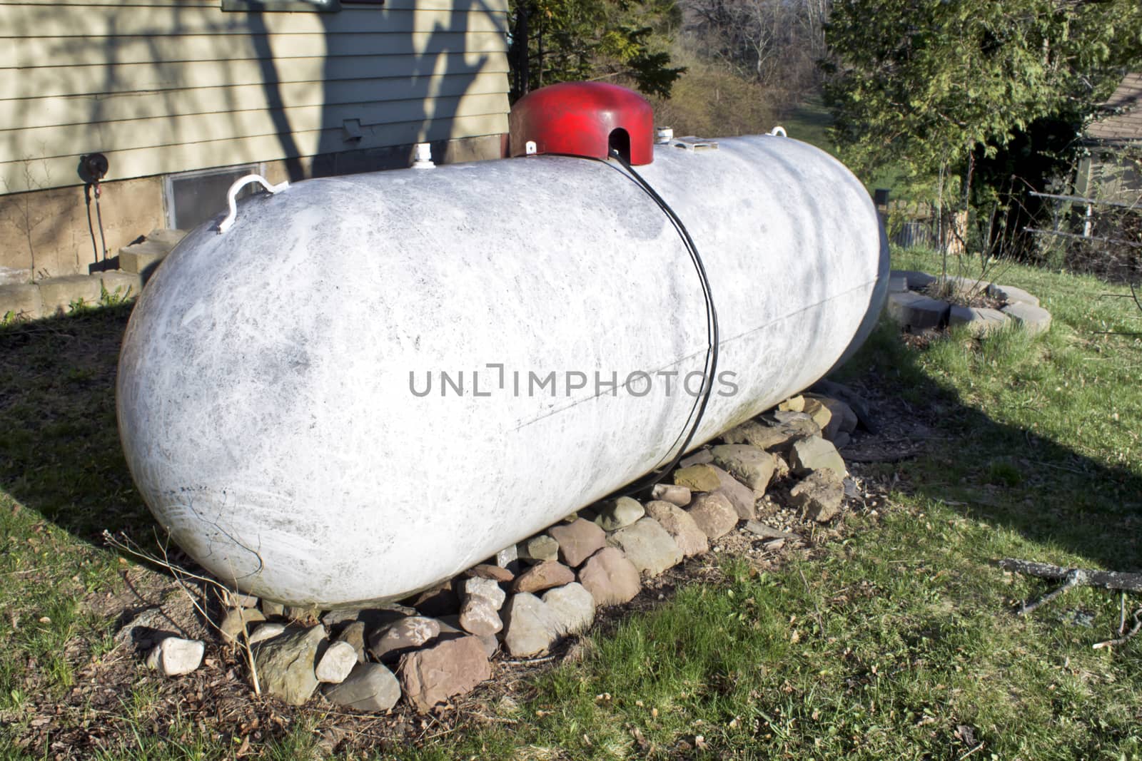 Giant white propane tank on the side of house.