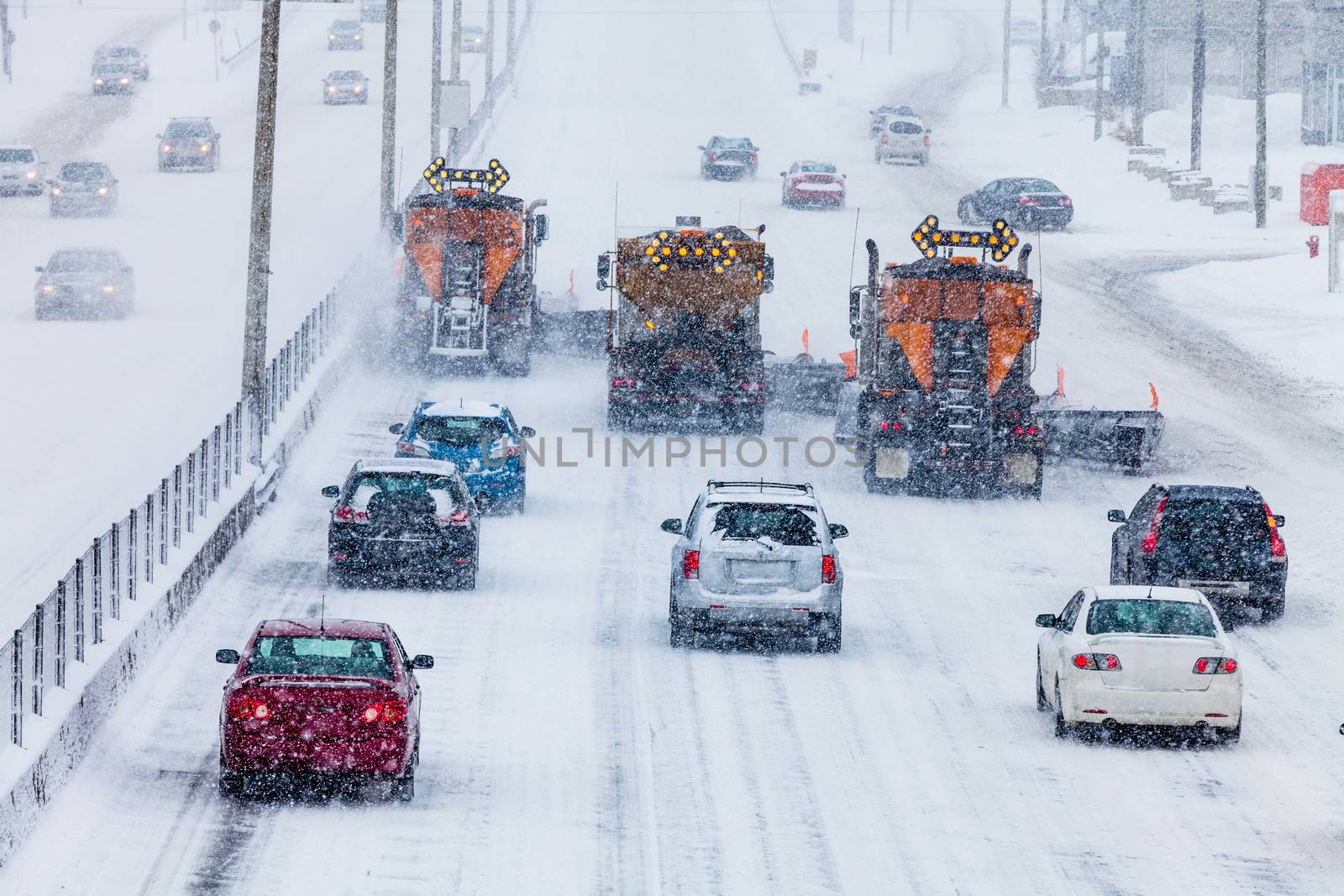 Tree Lined-up Snowplows Removing the Swno the Highway on a Cold Snowy Winter Day