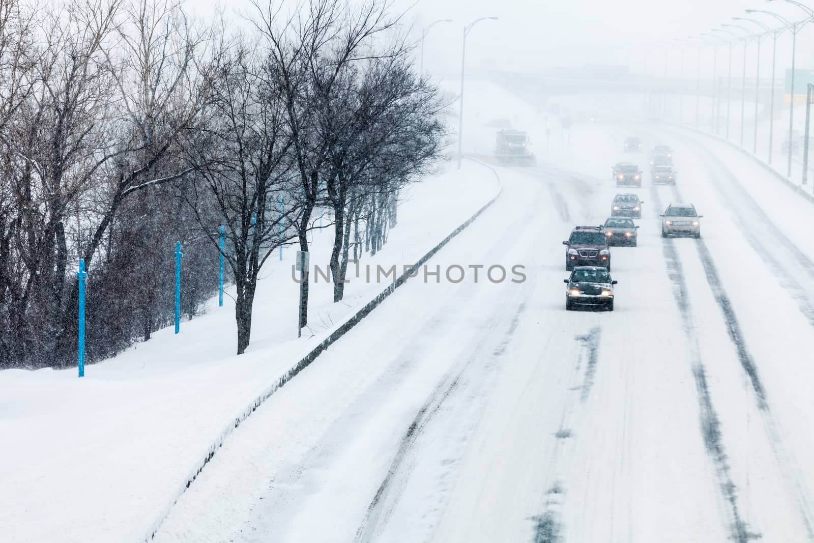 Traffic and Snowstorm on the Highway During a Cold Winter day