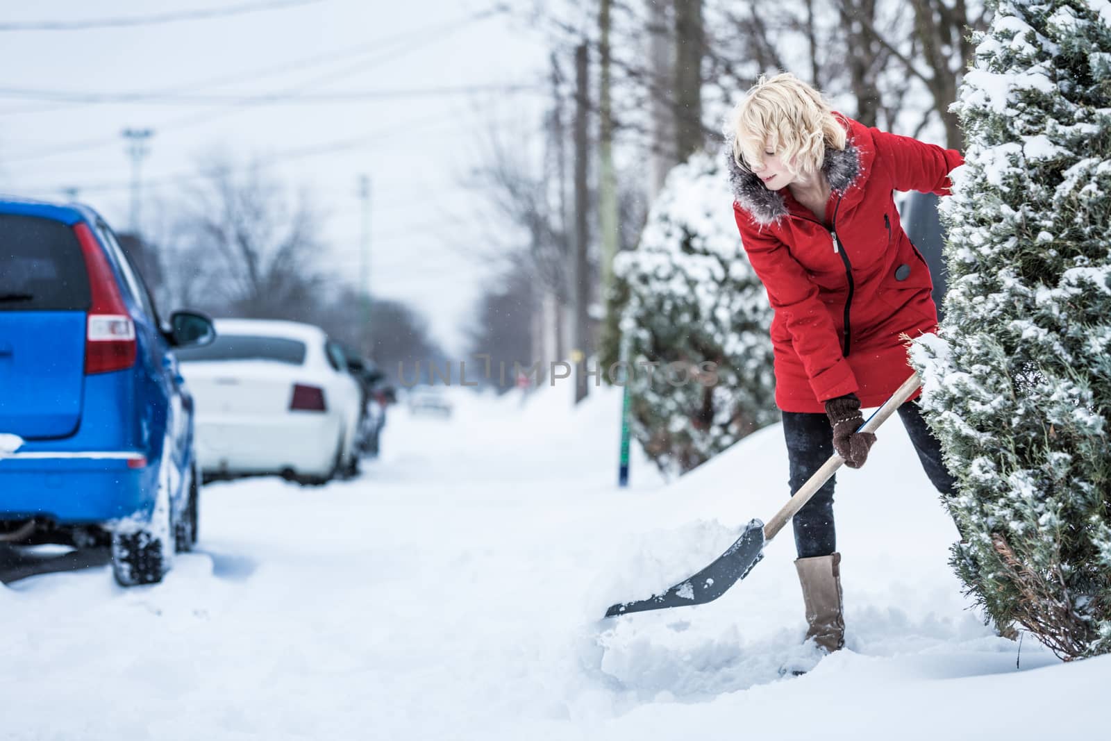 Woman Shoveling her Parking Lot after a Snowstorm