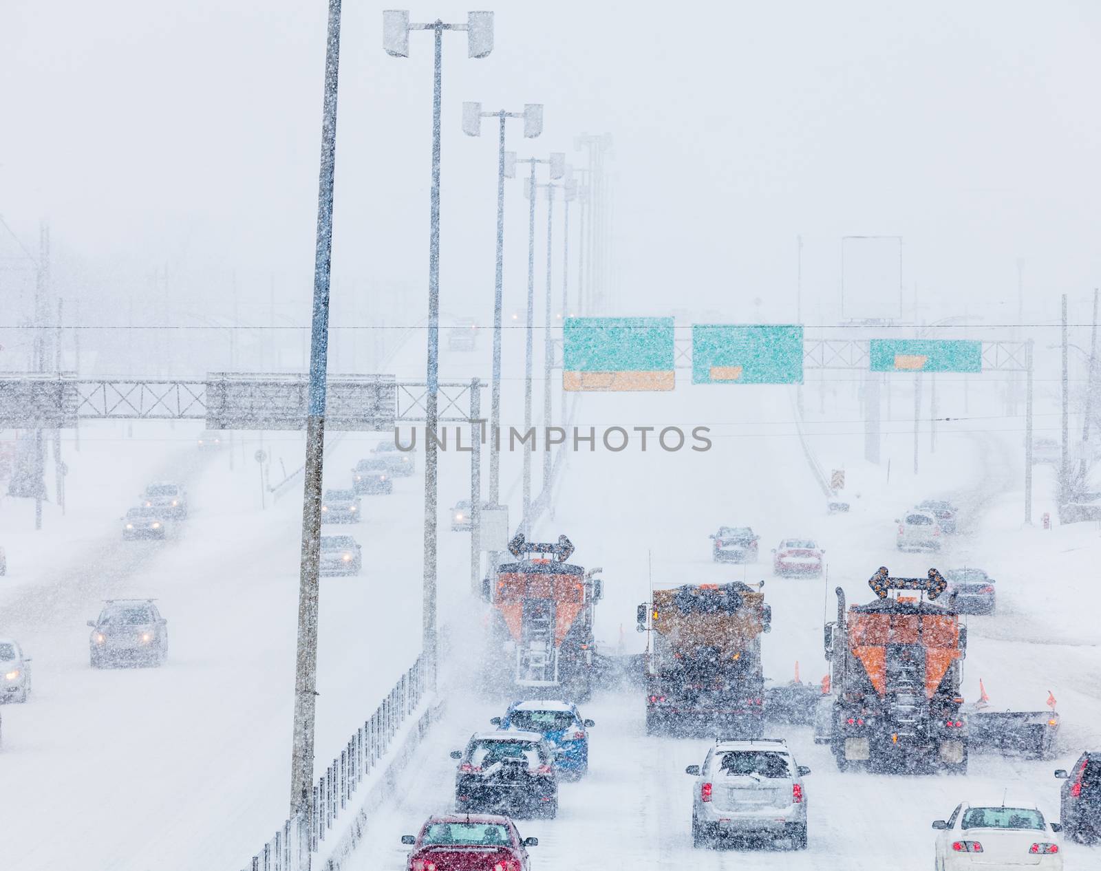 Tree Lined-up Snowplows Removing the Swno the Highway on a Cold Snowy Winter Day