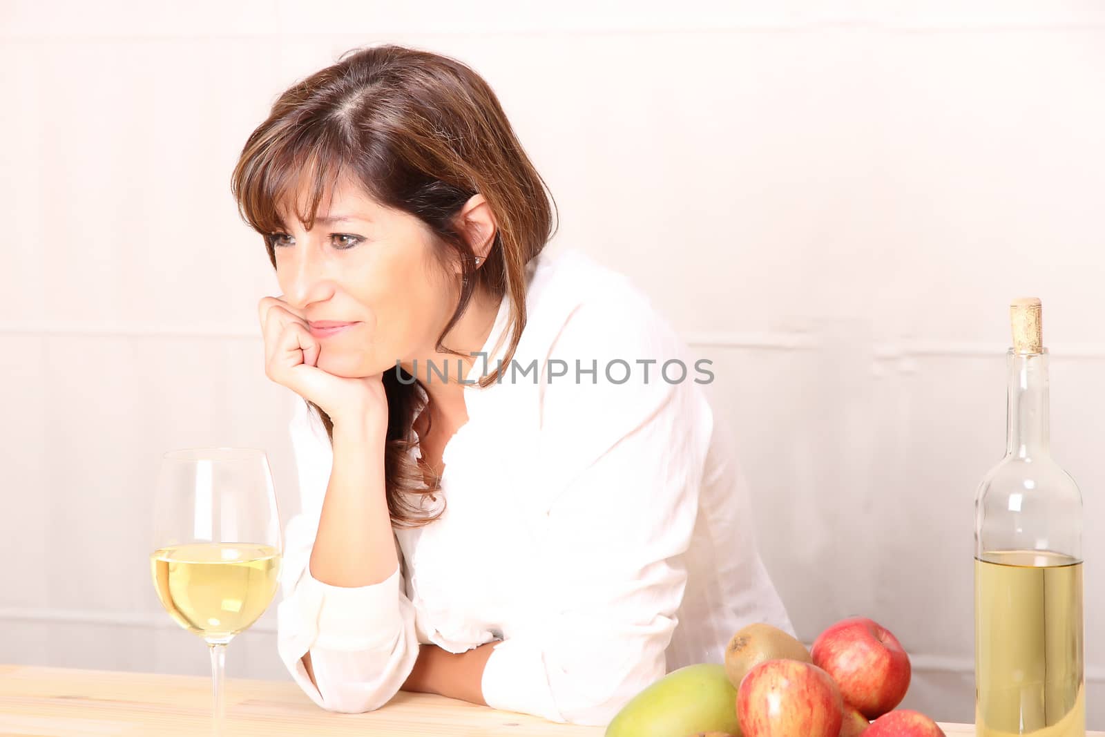 A beautiful mature woman with a glass of white wine.