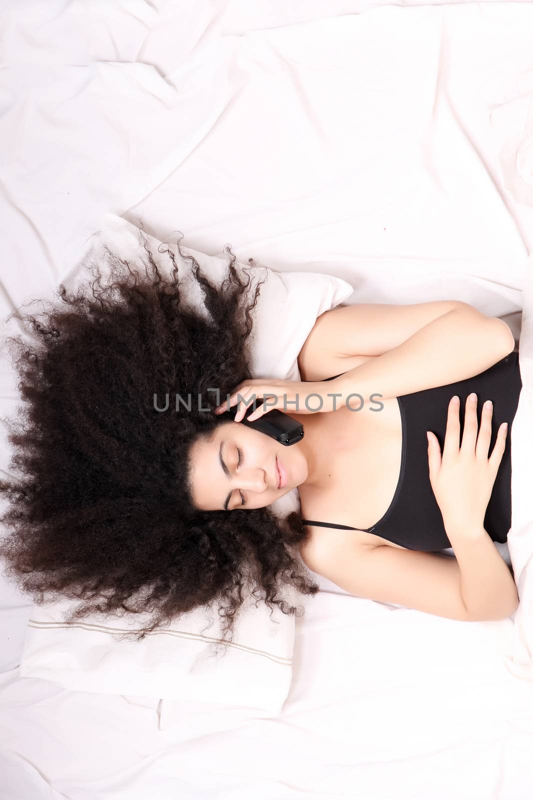 A young latin woman dreaming and sleeping while hugging herself.