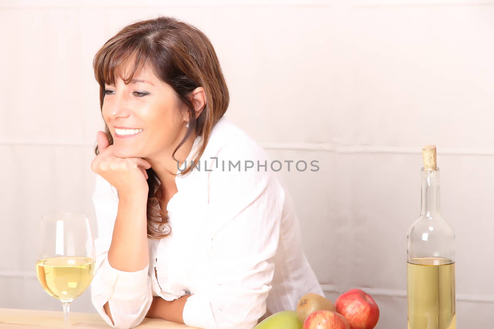 A beautiful mature woman with a glass of white wine.