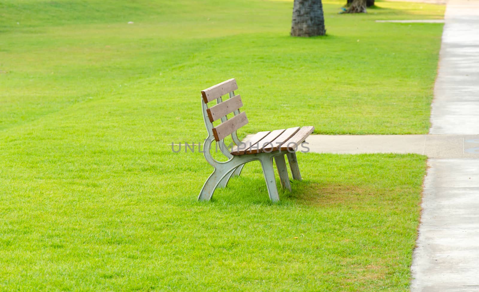 Brown chair in the garden side of paved road.