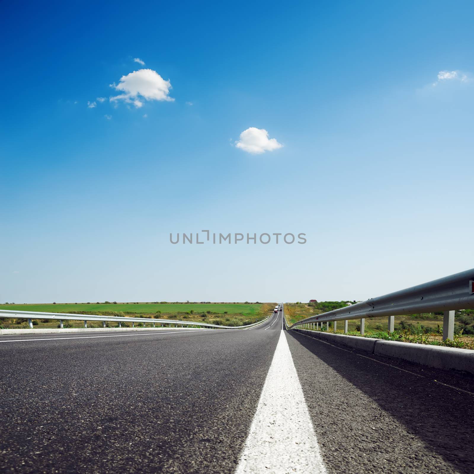 asphalt road to horizon in blue sky by mycola