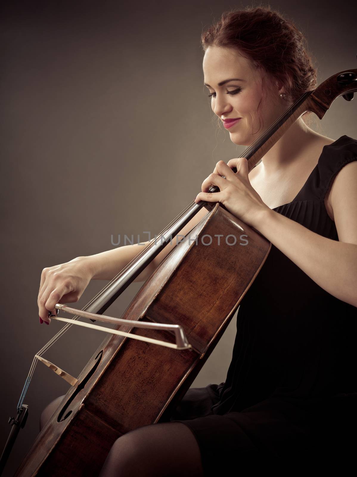 Smiling Cellist playing her old cello by sumners