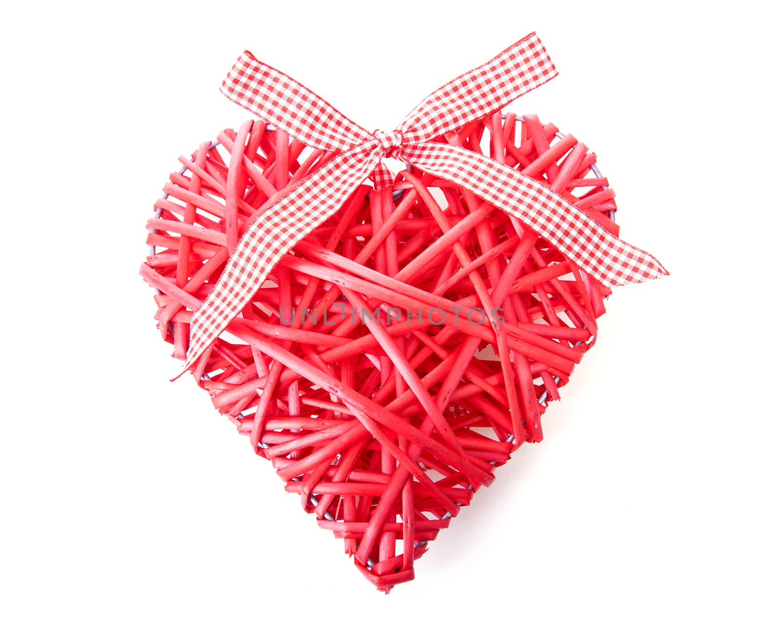 Red heart made of reed over white background