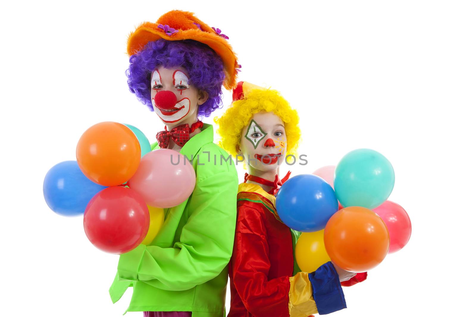 children dressed as colorful funny clowns with balloons over white background