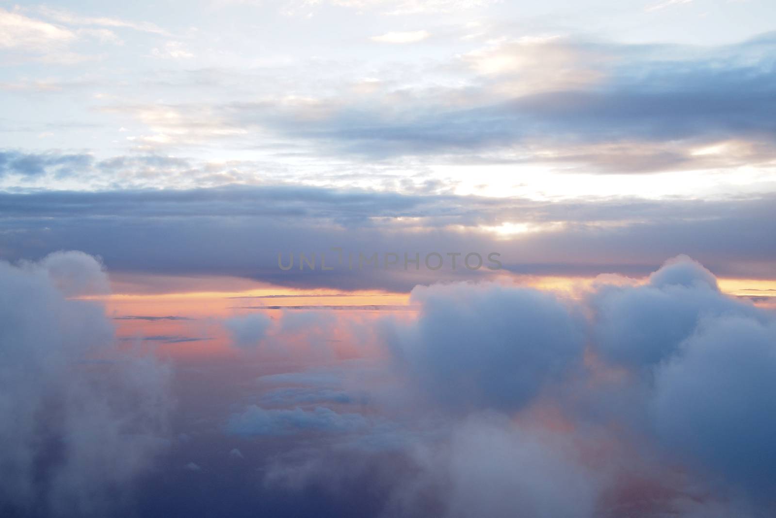Sunrise above clouds during a flight by stockyimages