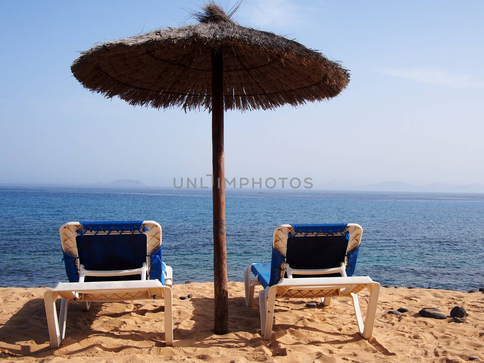 Sand beach with chairs by stockyimages