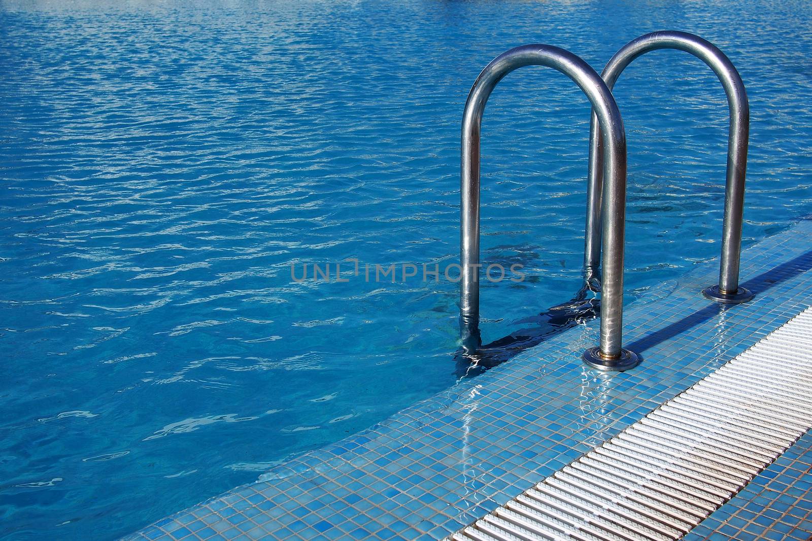 Swimming pool with steel ladder by stockyimages