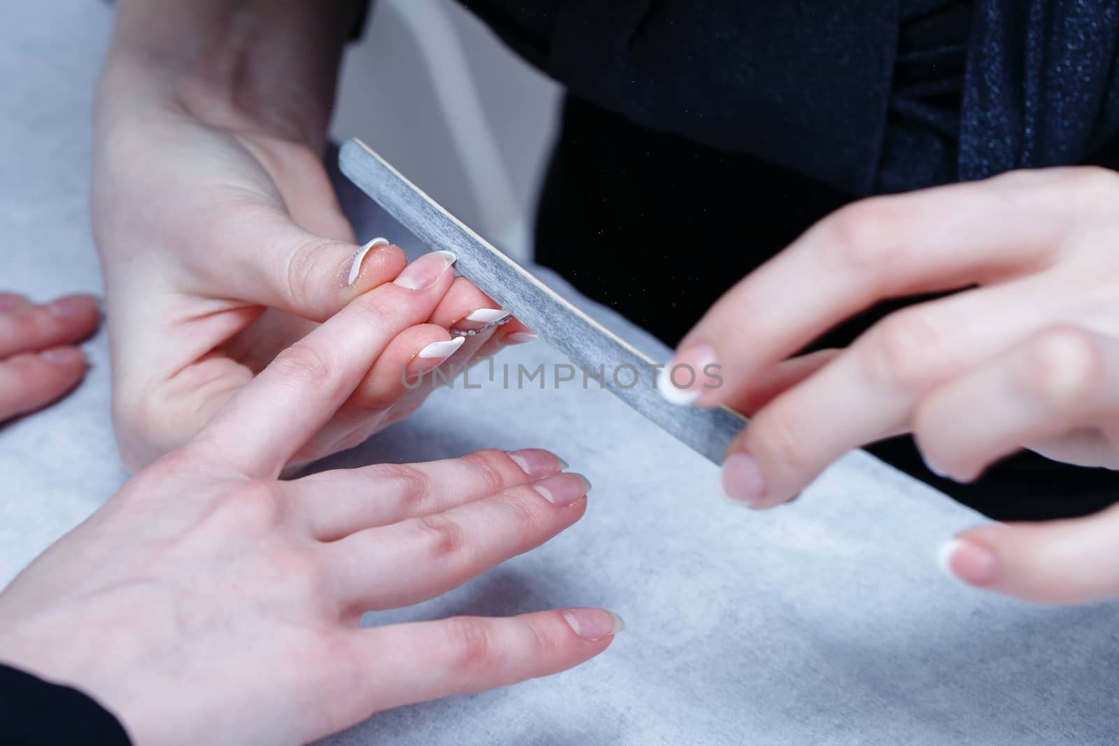 Manicurist nails handles client nail file shot closeup