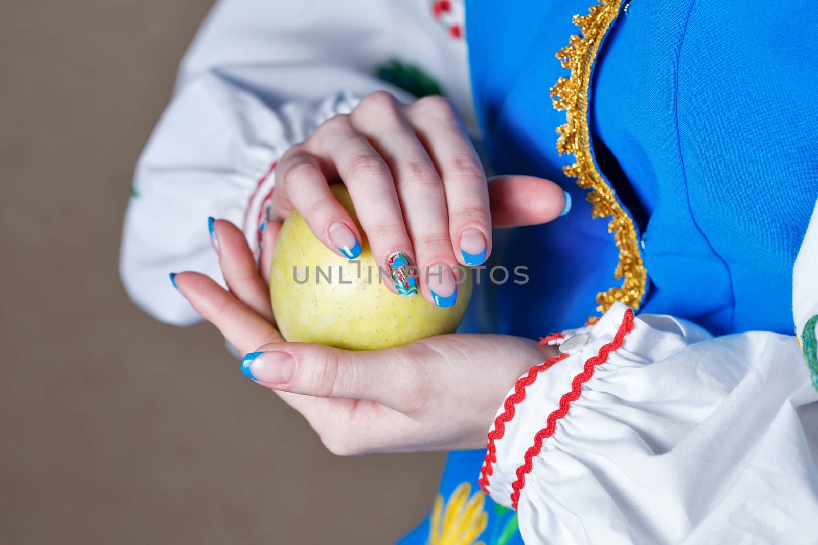 Girl holds in her hands with manicure ripe apple shot close up