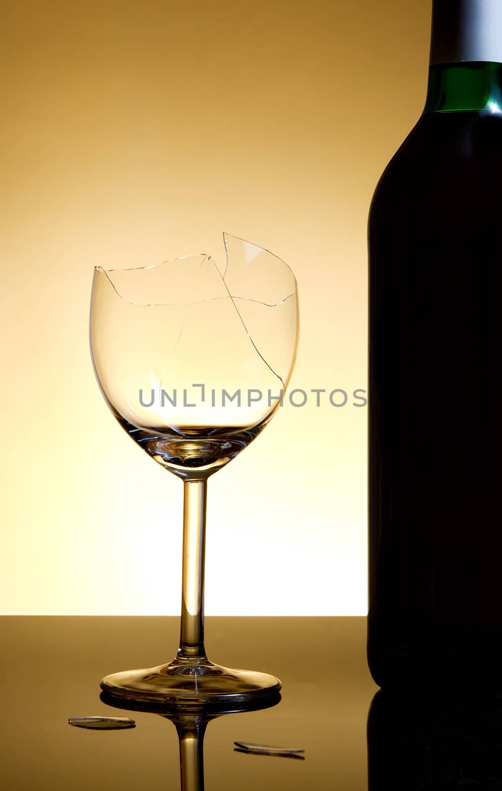 Vine bottle and broken glass on orange background