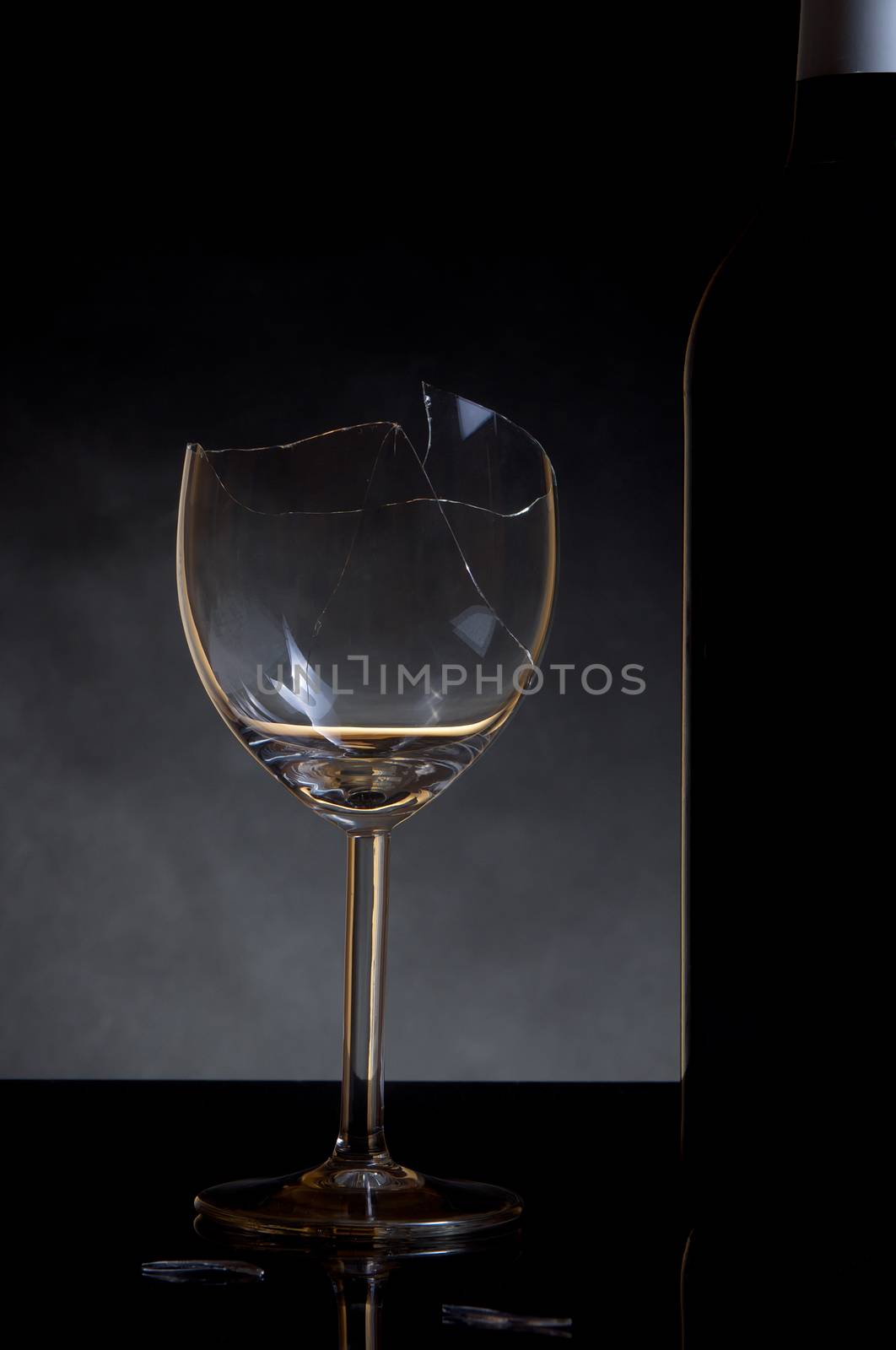 Vine bottle and broken glass on dark background by anderm