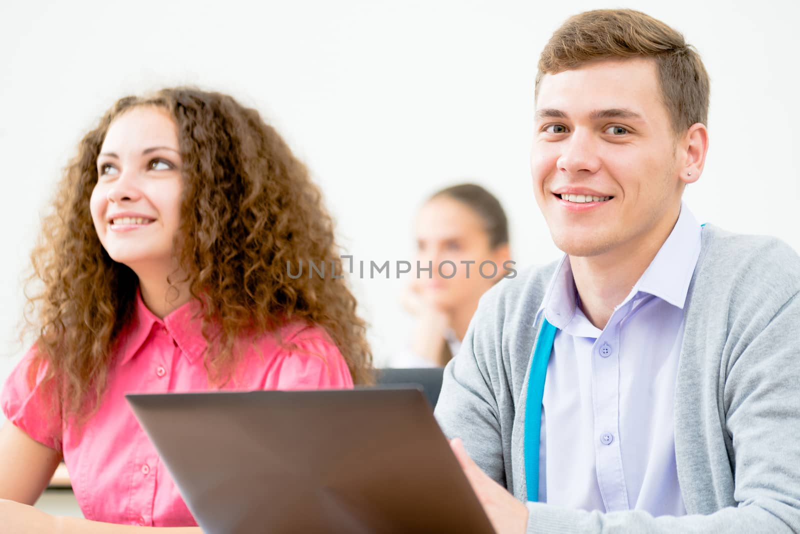 Portrait of a young student in the classroom, working with a laptop