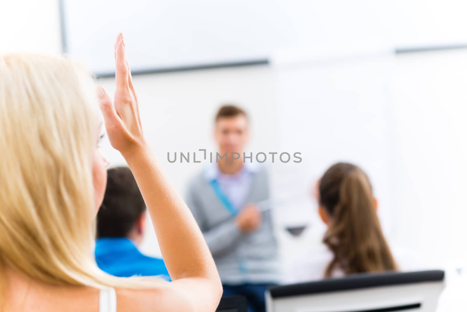 image of a female hand raised in university classroom