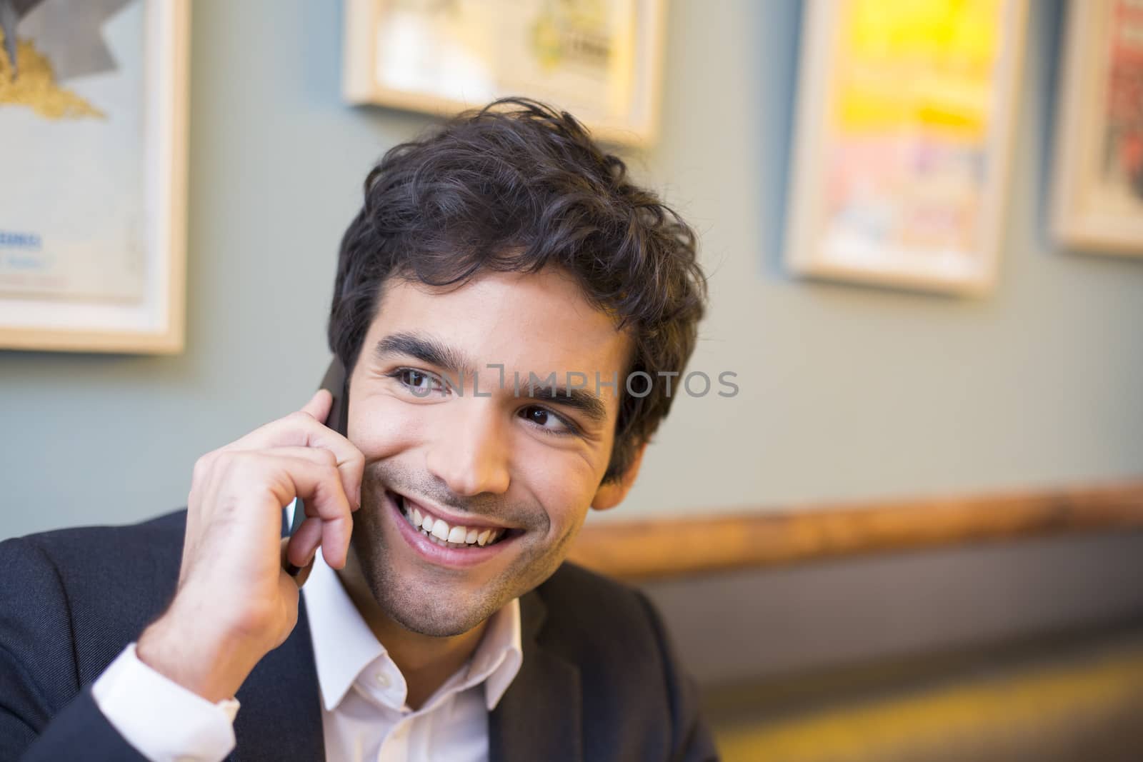 Handsome man calling with a cell phone in coffee bar by LDProd