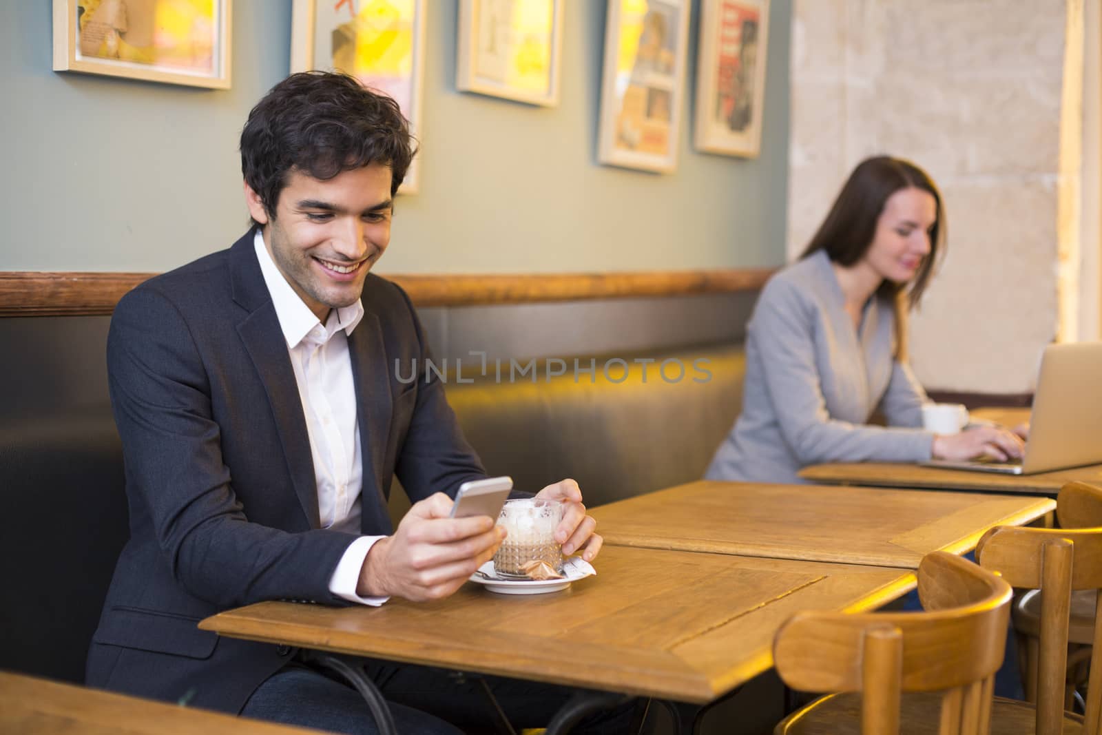 Handsome man using a cell phone in coffee by LDProd