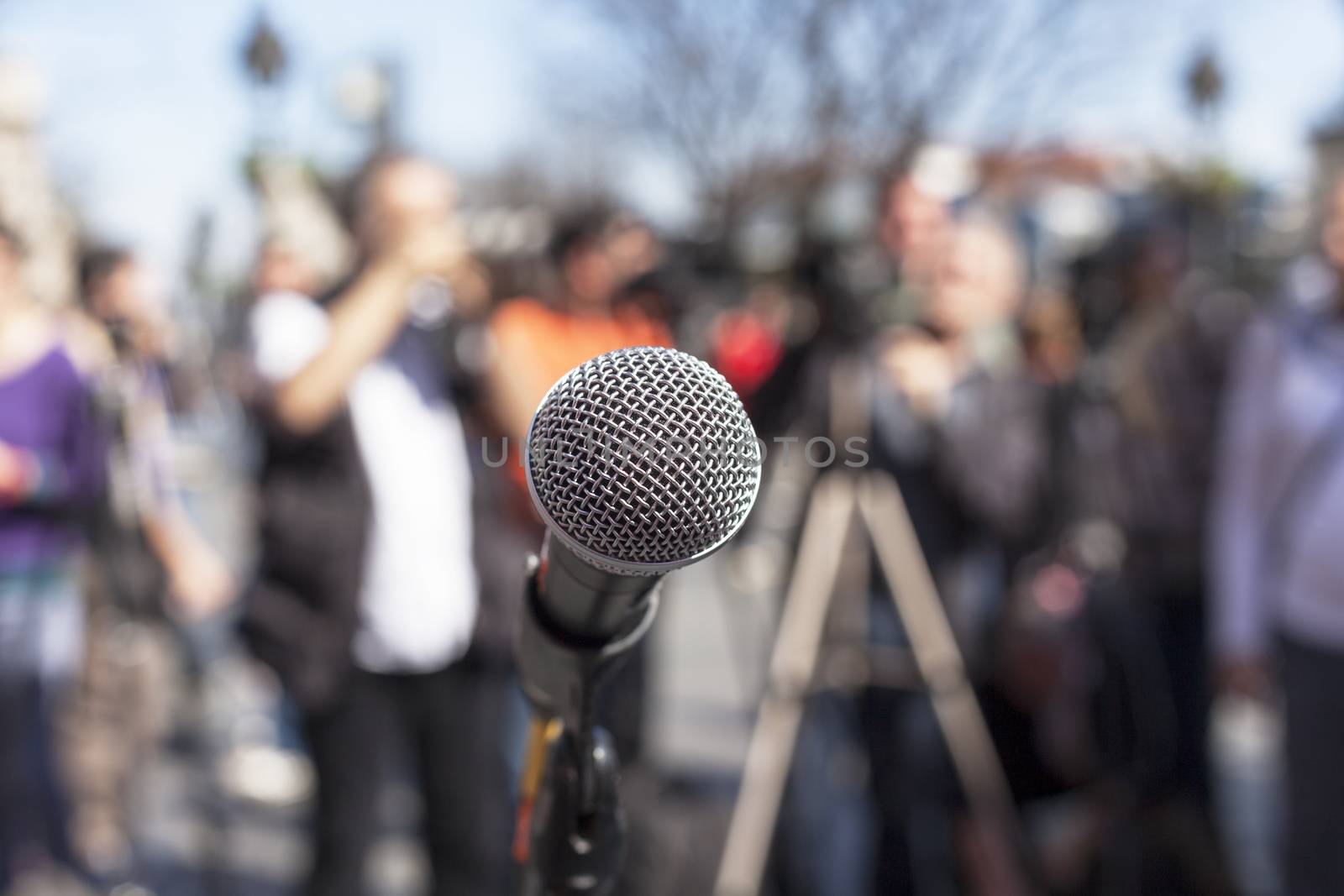 Microphone in focus against blurred audience