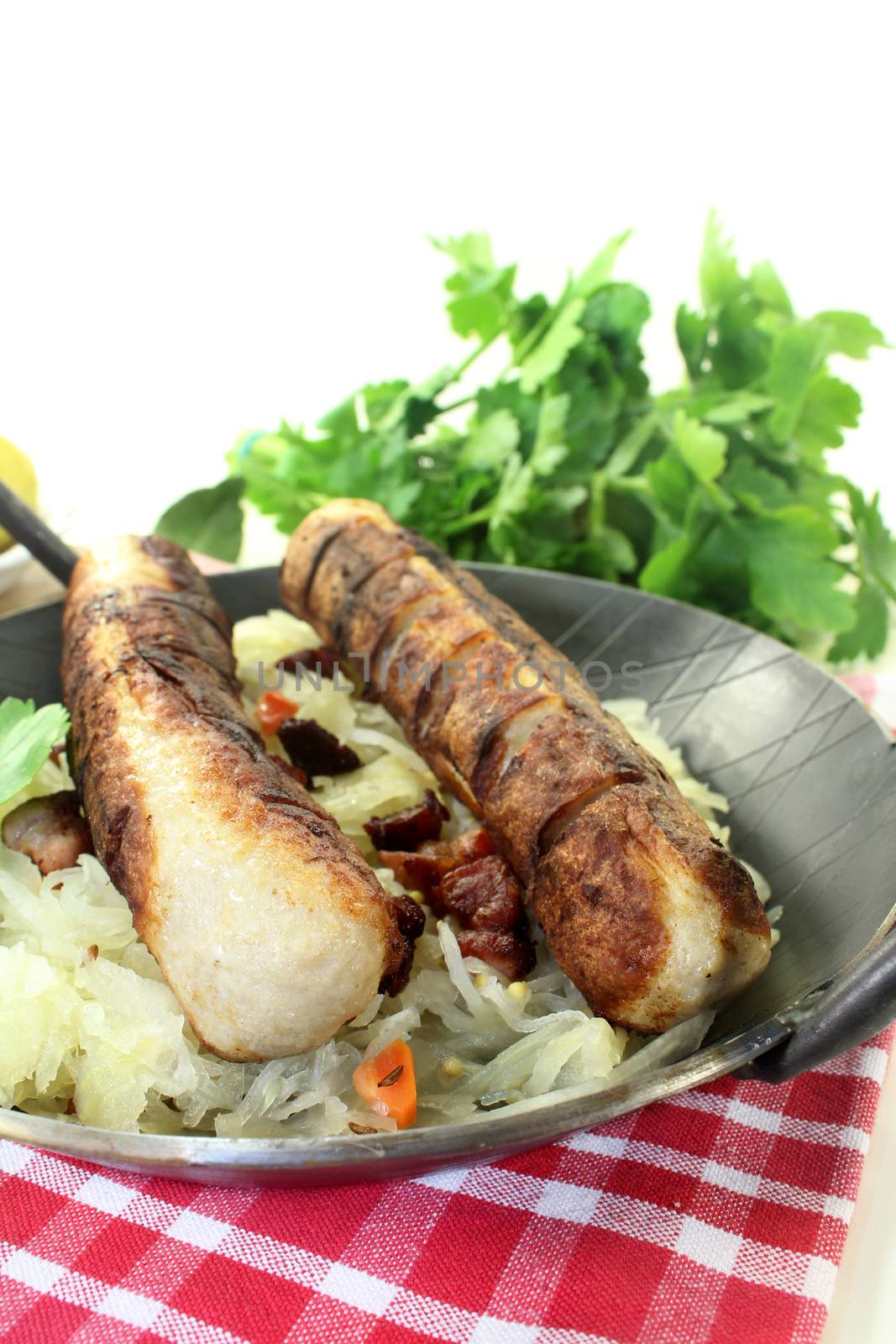 a pan with sourcrout and fried sausage